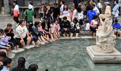 圖為游客在溫泉扎堆泡腳。